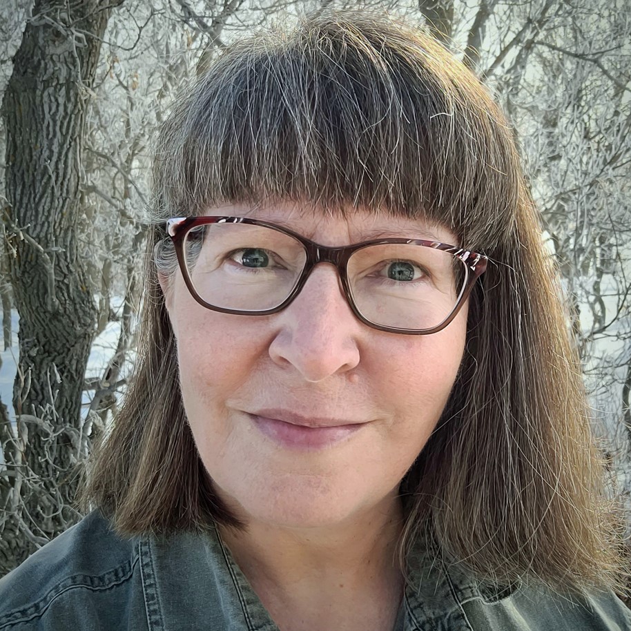 Brenda Schmidt - SK Arts nominator - Indigenous woman with short grey hair. She is wearing bangs and glasses.