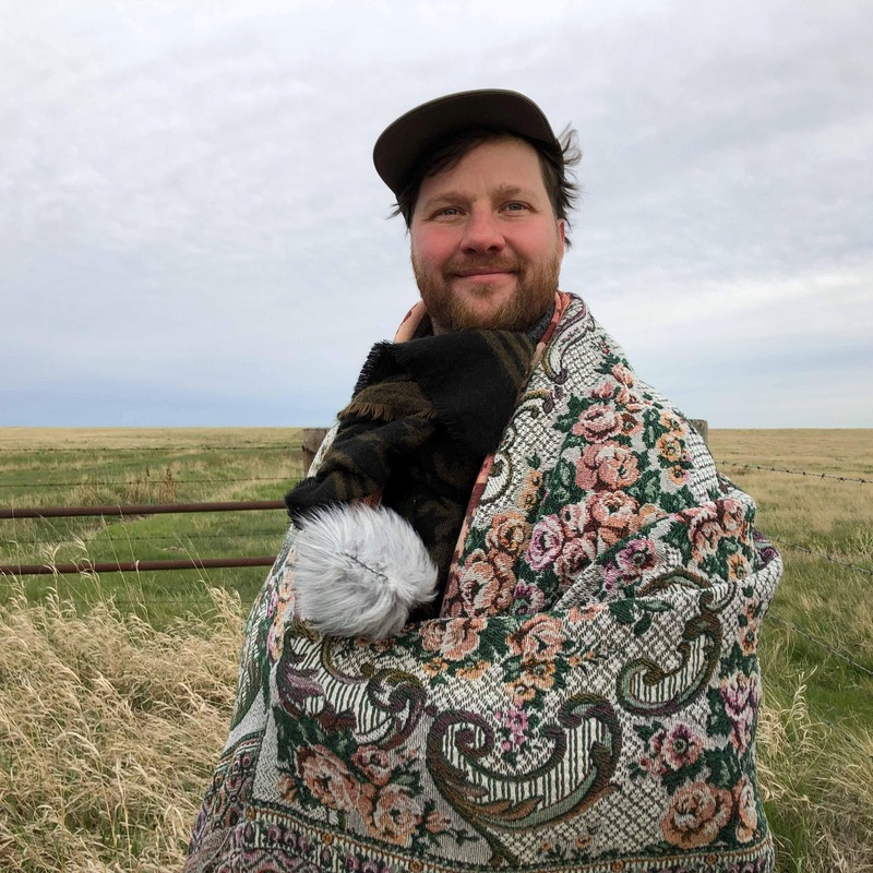 Jeff Morton 1 by Esperanza Sanchez Espitia - Man standing in open field in blanket