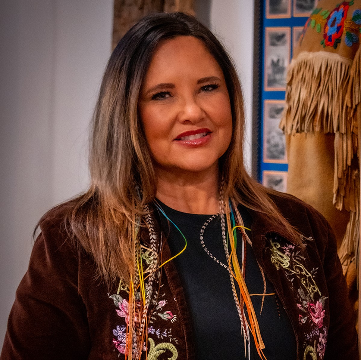 Lisa Bird-Wilson - Portrait of Indigenous woman with lack and blonde Ombre hair smiling.