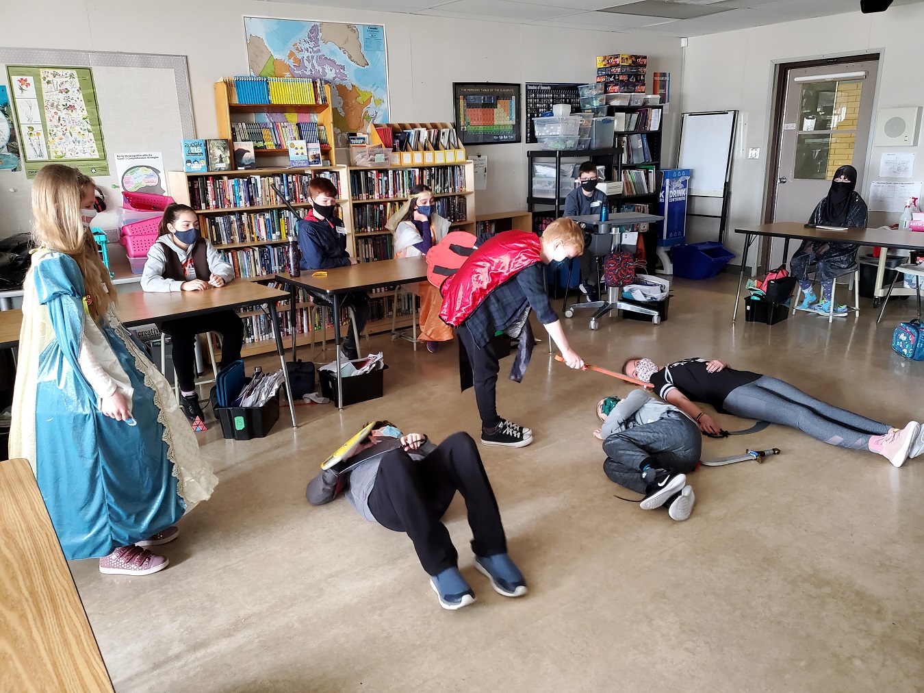 A group of students dressed in costumes act out a scene from a Shakespeare play.