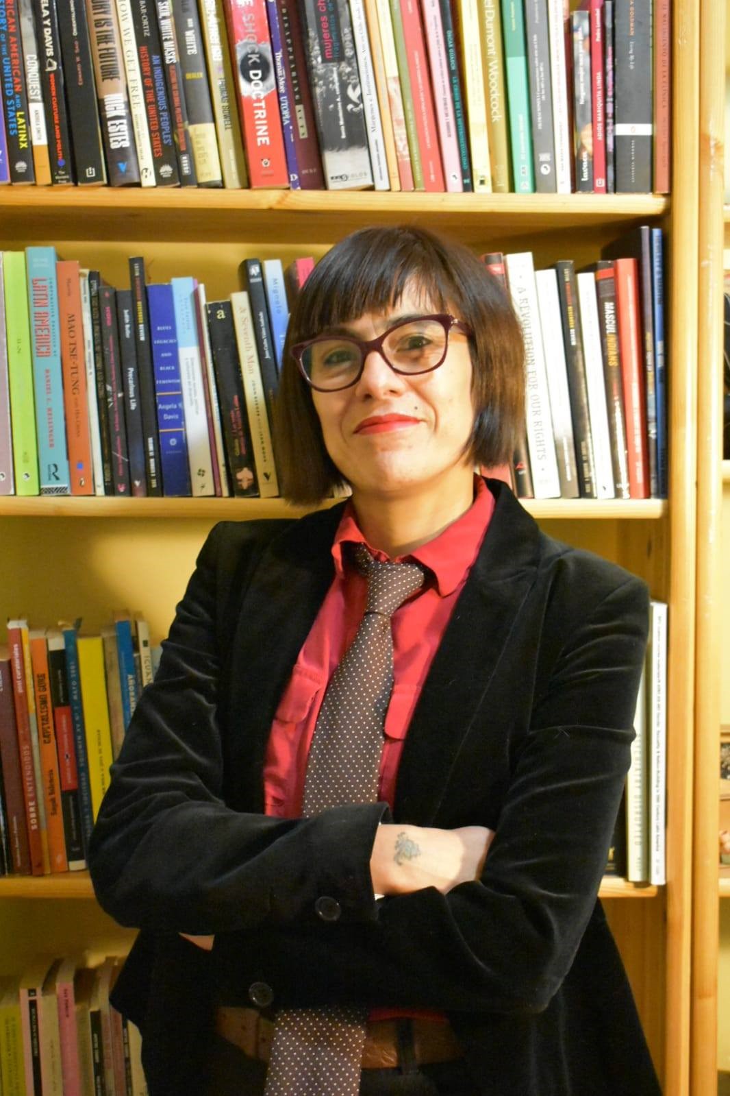 Manuela Valle-Castro standing in front of a bookshelf