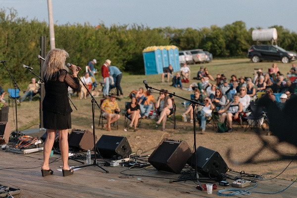 A singer performs for a small crowd at FarmFest