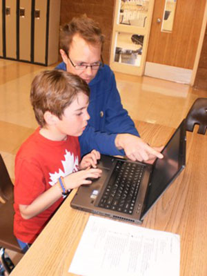 Allan Dotson helps a Grade 3 student edit the graphic novel