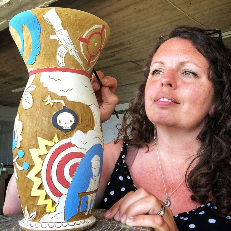 Carole Epp - Woman with curly hair decorating a ceramic vase