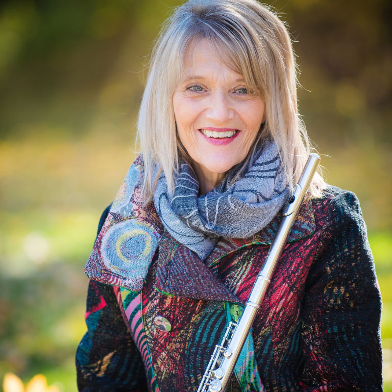 Laura Pettigrew - Older blonde woman smiling with a musical instrument
