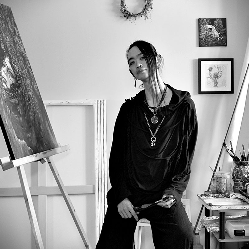 Qiming Sun -  Black and white photo of Asian man sitting in an art studio